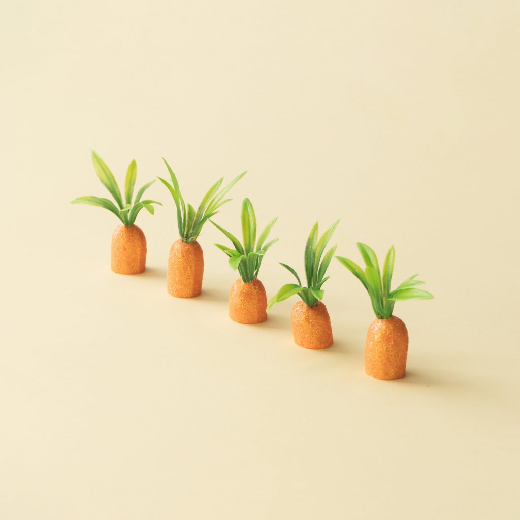 Carrots on pastel yellow. Minimal Easter concept. Spring minimal composition.